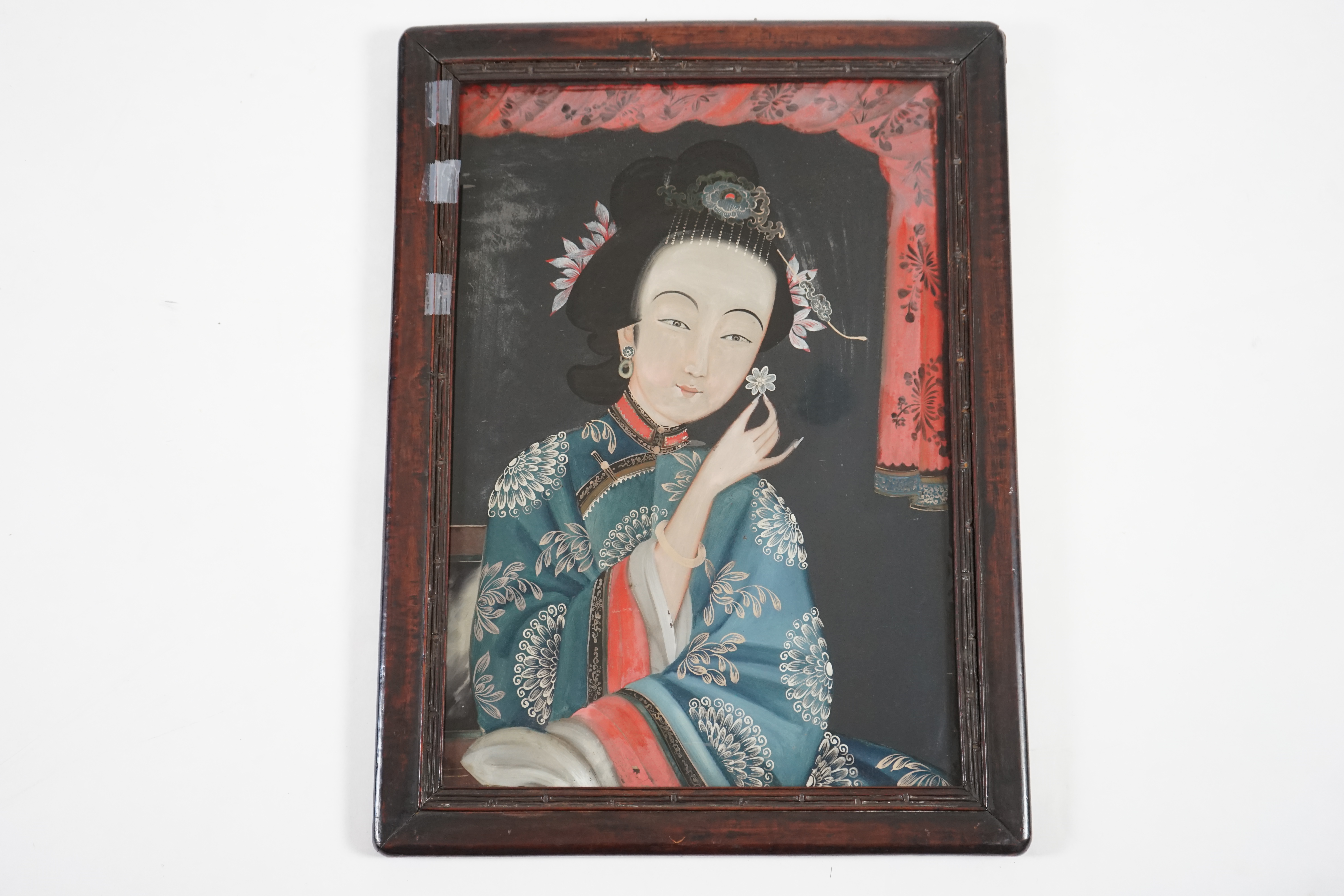 A Chinese reverse painting on glass of a lady holding a flower, 19th century